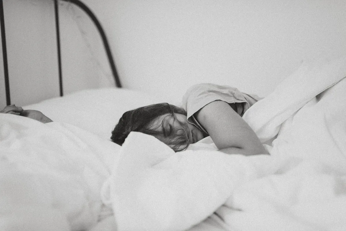 Schwarz-weißes Bild mit Frau, die im Bett liegt und Schläft
