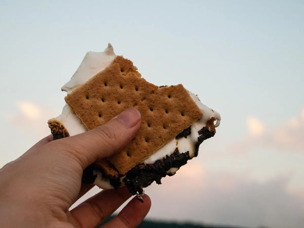 S'Mores mit einer Hand in die Luft gehalten