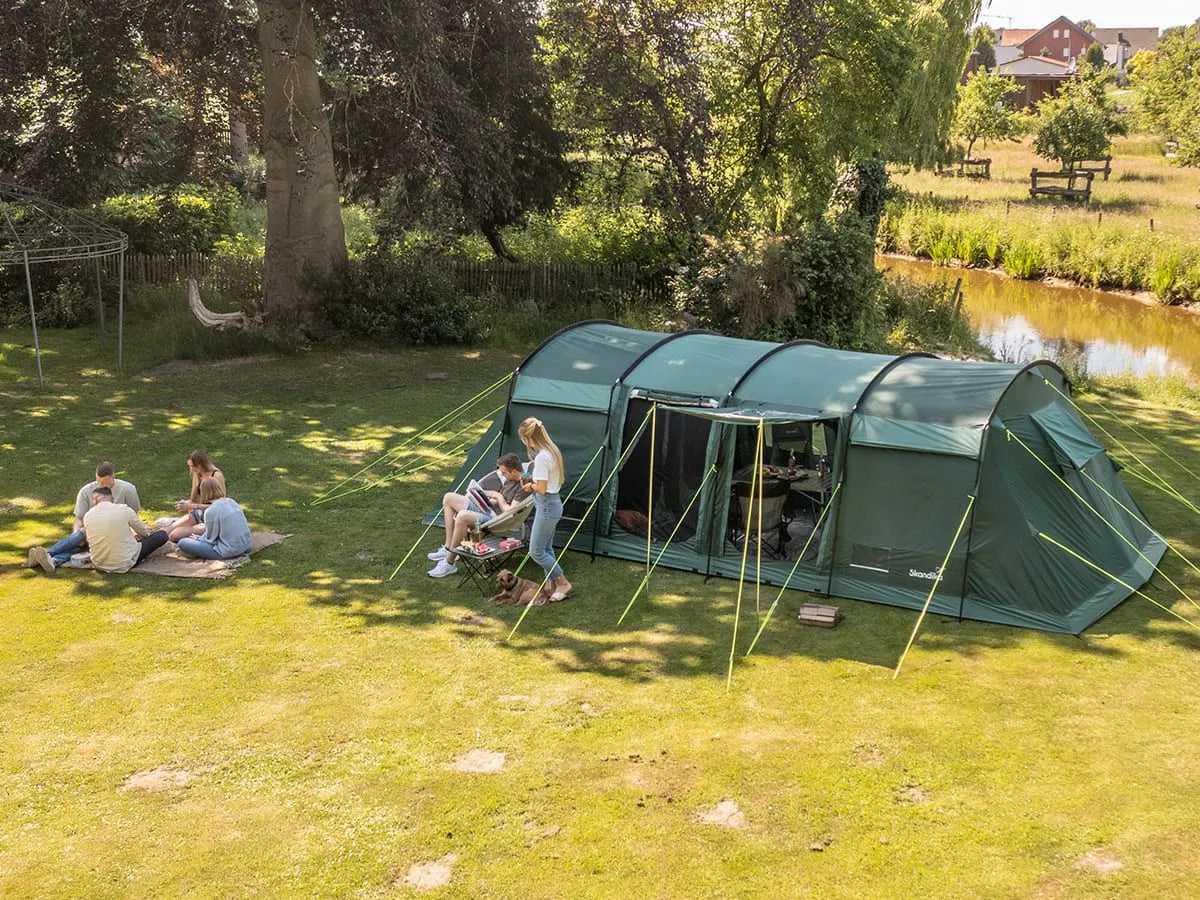 Montana 10 Sleeper Protect in grün auf einer Wiese im Schatten aufgestellt