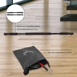 Schwarze, zweigeteilte Stange mit Griffen auf einem Holzfußboden. Neben der Stange ein schwarzer Aufbew sacks mit bunten Gurten.