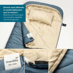 Schlafsack in Blau und Beige mit integrierter Kopfstütze. Label „Skandika EST. 2004“ sichtbar. Ergonomisches Design.
