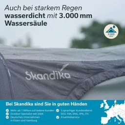 Wassertropfen auf einem grauen Zelt mit dem Schriftzug „Skandika“. Wetterbedingungen scheinen regnerisch.
