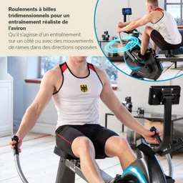 Mann in Sportbekleidung sitzt auf einem Rudergerät und hält das Ruder mit beiden Händen. Im Hintergrund sind Fenster und ein Regal.