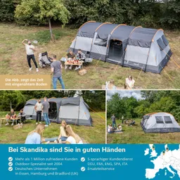 Zelt auf einer Wiese mit Personen, die an einem Tisch sitzen und essen. Im Hintergrund stehen weitere Zelte.