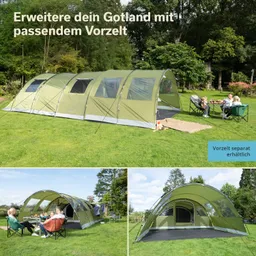 Grünes Zelt mit Vorzelt auf Wiese, daneben sitzende Personen in Campingstühlen und Tisch. Bäume im Hintergrund.