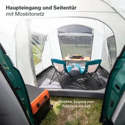 Zelt mit Moskitonetz, Innenansicht. Zwei Stühle und ein Tisch stehen darauf. Ein orangefarbener Kühlbox ist sichtbar.