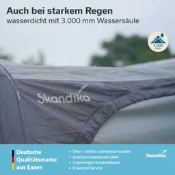Zeltstoff mit Wasserdrops, Logo "Skandika", Schriftzug über Wasserdichtigkeit bei starkem Regen, grauer Hintergrund.