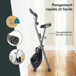 Fahrrad-Ergometer in einem Raum. Grau-schwarzes Design, mit abnehmbarem Sensor und einer drehbaren Kurbel. Schriftzüge über den Eigenschaften.