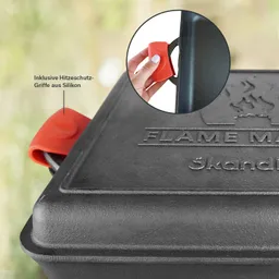 Schwarze, rechteckige Grillpfanne mit einem roten Silikongriff. Im Hintergrund unscharfe grüne Elemente.
