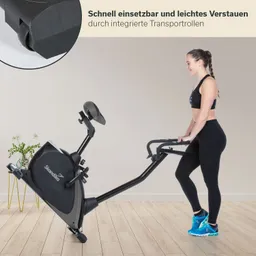 Fitnessgerät in einem modernen Raum, Person steht daneben und hält das Gerät. Pflanzen im Hintergrund.