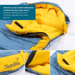 Blau-gelber Schlafsack mit Innentaschen, teilweise geöffnet. Markenlogo „Skandika“ sichtbar. Text in der oberen Ecke.