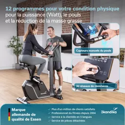 Fitnessgerät steht im Raum, eine Person sitzt und eine andere steht daneben. Display und Bedienelemente sind sichtbar.
