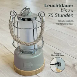 Akku-Laterne mit Metallgitter, integriertem Seilgriff und Holzsockel. An der Basis befindet sich ein Micro-USB-Anschluss.