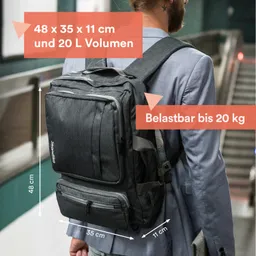Grauer Rucksack mit Maßen und Volumeninformationen auf einer Person, die einen Anzug trägt, im Innenraum eines Gebäudes.