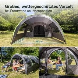 Zelt mit abgerundetem Dach und großen Fenstern, umgeben von Rasen und Bäumen. Menschen sitzen am Tisch.