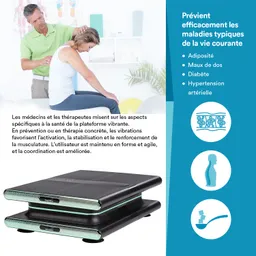 Eine Person sitzt auf einem Tisch, während eine andere Person eine Behandlung durchführt. Im Vordergrund steht ein Vibrationsgerät. Im Hintergrund sind mehrere farbige Objekte und eine Pflanzenreihe sichtbar.