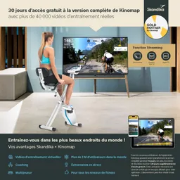 Frau auf einem Heimtrainer vor einem Fernseher mit Bild des Kinomap-Programms. Smartphone und Tablet sind sichtbar.