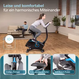 Ein Heimfahrrad in schwarz mit blauen Elementen steht in einem Wohnzimmer. Im Hintergrund sind ein Sofa und ein Beistelltisch sichtbar.