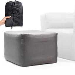 Grauer Pouf neben einem weißen Sessel. Eine Person hält eine schwarze, gefaltete Tasche.