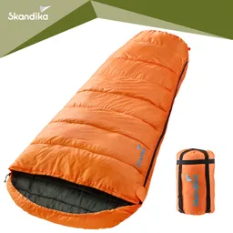 Orangener Schlafsack mit extrudierter Struktur, halb geöffnet und neben einem kompakten Packsack in derselben Farbe.
