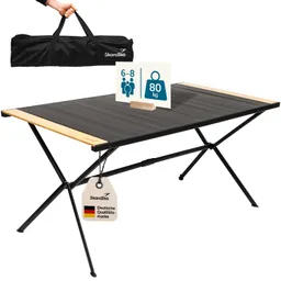Faltbarer Tisch mit schwarzer Oberfläche und Holzleisten. Inklusive Tragetasche und Hinweisschild zu Gewicht und Personenanzahl.