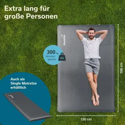 Graue Matratze auf grünem Gras, Person liegt entspannt darauf, mit den Armen hinter dem Kopf. Maße: 198 cm x 130 cm.