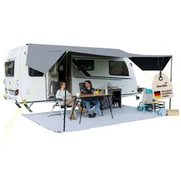 Ein Wohnwagen mit grauem Vordach, davor stehen ein Tisch und zwei Stühle. Auf dem Tisch sind Getränke und Obst. Zwei Personen sitzen entspannt.
