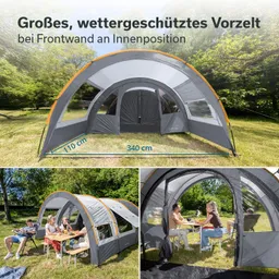 Großes, graues Vorzelt mit transparenten Fenstern, in einer grünen Umgebung. Personen sitzen an einem Tisch im Innenraum.