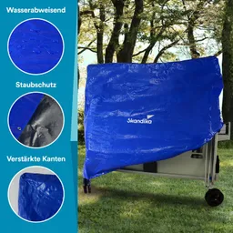 Blauer Schutzbezug, teilweise über ein Möbelstück gezogen, mit Wassertropfen, verstärkten Kanten, im Freien zwischen Bäumen.