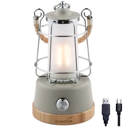 Tischlampe in Lanternenform mit Glaskörper, Metallgitter, Holzsockel und USB-Kabel. Schalter an der Vorderseite.