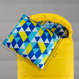 Gelbes Schlafsackmaterial mit einem bunten Kissen in geometrischem Muster, Kissenmaß 45 x 40 cm. Schlafsacköffnung sichtbar.