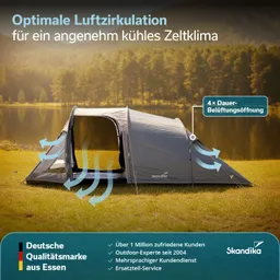 Zelt in grauer Farbe auf einer Wiese mit Öffnungen zur Luftzirkulation, umgeben von Bäumen und Wasser.