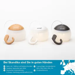 Drei tragbare Lampen mit runden, weißen Körpern und unterschiedlich farbigen Oberteilen (Holz, weiß, schwarz) stehen nebeneinander.