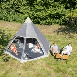 Zelt im Freien mit zwei Personen drinnen, eine liest, die andere sitzt. Draußen sitzen zwei Personen an einem Tisch mit Getränken.