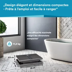Eine digitale Waage auf einem Holzboden, daneben eine weiße Badewanne. Fenster mit Blick auf Stadtlandschaft.