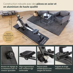 Rudergerät auf einer Matte im Wohnraum. Angrenzende Möbel: zwei Sessel und ein Tisch. Holzfußboden und Teppich sichtbar.