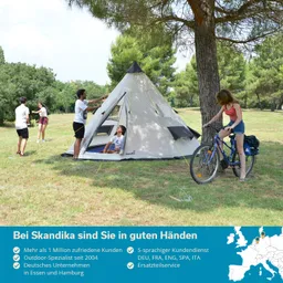 Trekkingzelt auf einer Wiese umgeben von Bäumen, mit Personen, die sich mit dem Zelt beschäftigen und einer Person auf einem Fahrrad.