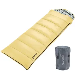 Gelber Schlafsack mit Steppung und grauem Innenfutter, daneben ein grauer Packsack.