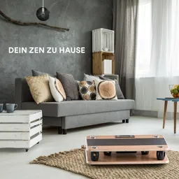 Graues Wohnzimmer mit einer Couch, Kissen und einem kleinen Tisch. Ein Teppich und Holzregale sind sichtbar.