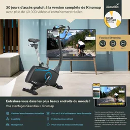Fahrrad-Ergometer in einem modernen Raum. Im Hintergrund ein TV-Gerät mit Trainingsvideos. Auf einem Tablet Informationen zum Training.