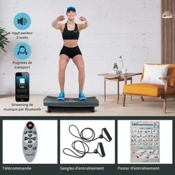 Person steht auf einer Vibrationsplatte in einem Wohnzimmer. Neben der Platte sind ein Smartphone, eine Fernbedienung, Widerstandsbänder und ein Trainingsposter.