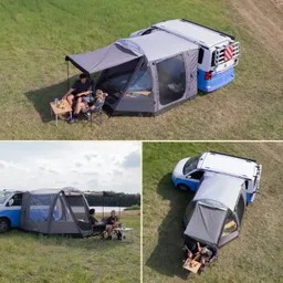 Zelt mit grauer Plane steht neben einem blauen Fahrzeug. Zwei Personen sitzen an einem Tisch mit Getränken und Essen. Grüne Wiese im Hintergrund.