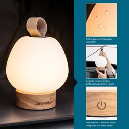 Eine batteriebetriebene Lampe in runder Form mit einem Holzsockel. Die Lampe hat eine Schlaufe zur Aufhängung.