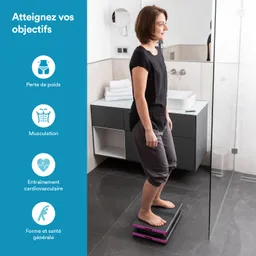 Eine Person steht barfuß auf einer digitalen Waage im Badezimmer. Im Hintergrund sind Handtücher und ein Waschbecken sichtbar.
