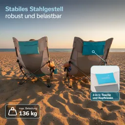 Zwei Liegestühle stehen am Strand, mit Blick auf das Meer. Sand und Sonnenuntergang im Hintergrund.