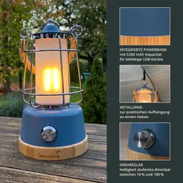 Laterne mit einem blauen Gehäuse, Metallschutz, Holzsockel und einer integrierten USB-Powerbank, auf einem Tisch im Freien.