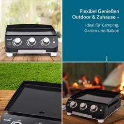 Eine schwarze Griddle mit drei Bedienelementen auf Holzuntergrund. Teile des Hintergrunds zeigen grünes Gras und ein unscharfes Lagerfeuer.