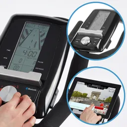 Display eines Fitnessgeräts mit Steuerungselementen, dazu ein Tablet mit einer Stadtansicht auf dem Bildschirm.
