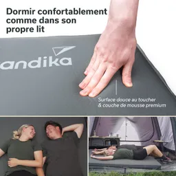 Eine Hand drückt auf eine graue Matte mit dem Logo „Kandika“. Unten liegen zwei Personen entspannt in einem Zelt.