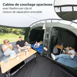 Zelt mit separaten Schlafkabinen. Zwei Personen sitzen an einem Tisch, eine Person liegt lesend in der Kabine.